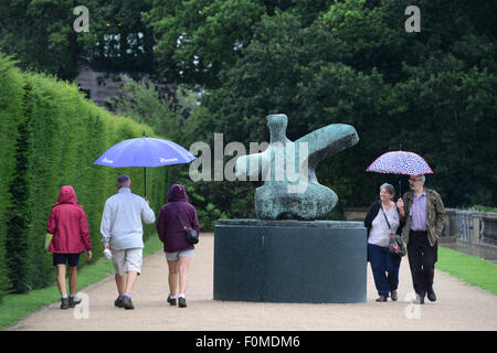 Wakefield, UK. 18. August 2015. Besucher Schutz vor dem Regen unter ihren Regenschirmen während eines Besuchs in Yorkshire Sculpture Park in der Nähe von Wakefield, West Yorkshire. Bild: Scott Bairstow/Alamy Live-Nachrichten Stockfoto