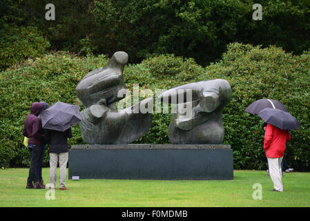 Wakefield, UK. 18. August 2015. Besucher Schutz vor dem Regen unter ihren Regenschirmen während eines Besuchs in Yorkshire Sculpture Park in der Nähe von Wakefield, West Yorkshire. Bild: Scott Bairstow/Alamy Live-Nachrichten Stockfoto