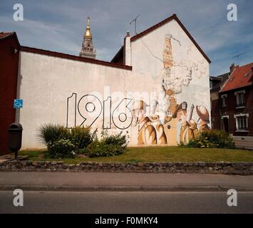 AJAXNETPHOTO. 2015. ALBERT. Frankreich. -GOLDENE JUNGFRAU - VERGOLDETE STATUE DER JUNGFRAU MARIA HÄLT INFANT JESUS EMPOR DOMINIERT DEN TURM DER BASILIKA NOTRE-DAME DES BREBIERES SICHTBAR HINTER DIESEM WANDBILD AUF EINER HAUSWAND IN DER STADT GEMALT. STATUE WURDE EIN ARTILLERIE-ZIEL FÜR DEUTSCHE GESCHÜTZE IM ERSTEN WELTKRIEG. AKTUELLE VERSION IST EINE NACHBILDUNG DES ORIGINALS, IM ERSTEN WELTKRIEG ZERSTÖRT. FOTO: JONATHAN EASTLAND/AJAX REF: GXR152906 4961 Stockfoto