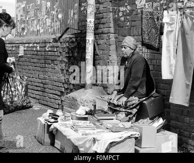 Verkauf von alten Büchern an einem Marktstand, unterhält eine ältere Rentner oder Babuschka mit einem potenziellen Verbraucher Stockfoto