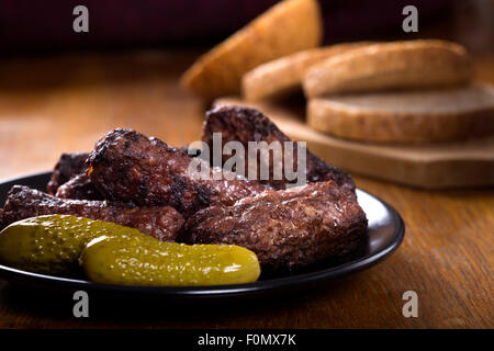 Traditionelles Essen "Mici" Würzige Frikadellen auf Teller mit sauren Gurken Stockfoto