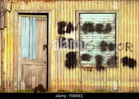 Tür geschlossen mit einem Schließfach auf alte Fabrik mit einem Graffiti in Punta Arenas, Chile. Stockfoto