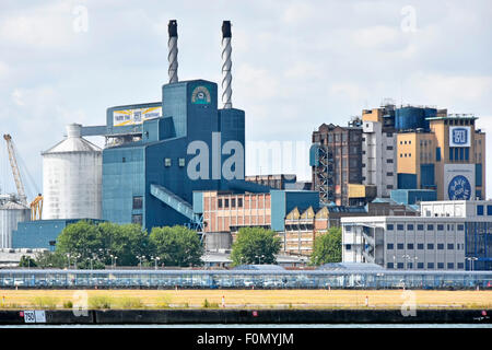 Fabrikgebäude der Zuckerraffinerie Tate und Lyle hinter der Start- und Landebahn des Flughafens London City Airport Silvertown Newham East London England Großbritannien Stockfoto