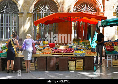 Kunden, Gemüse am Markt vom Abschaltdruck Inhaber, die in Obst und Gemüse Straße Marktstand in Aix-en-Provence in der Provence im Süden von Frankreich Stockfoto