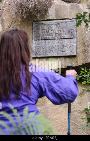 Eine weibliche Walker prüft die Plaque in Bowden Brücke Steinbruch, das erinnert an die mass Trespass Kinder Scout, Derbyshire UK Stockfoto