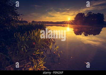 Vintage Foto von schönen Sonnenuntergang über ruhige See. Landschaft in Masuren fotografiert. Stockfoto