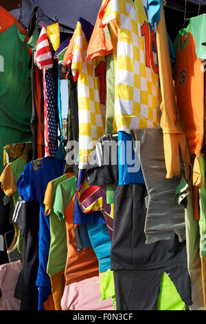 Eine Auswahl an bunten T-shirts hängend auf einem Gestell auf dem Markt von Mopti in Mali Stockfoto