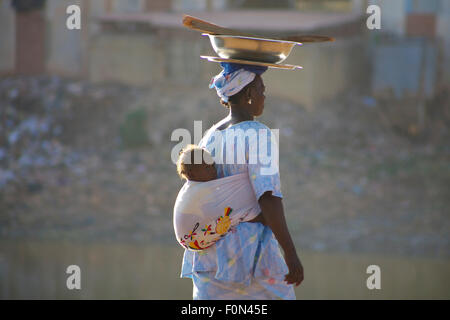 Unbekannte Frau mit einem Baby im Rücken in den Straßen von Mopti. 2010 Stockfoto