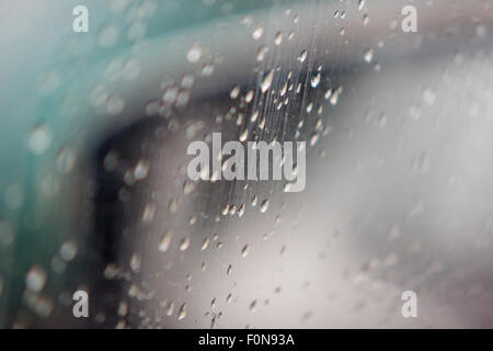 Tropfen von einem Regen Fluss hinunter auf Automobil Glas gießen Kummer Stockfoto