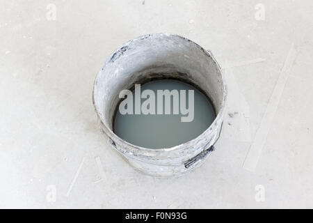 den Eimer mit schmutzigem Wasserkosten drinnen wo Reparatur durchgeführt wurde Stockfoto