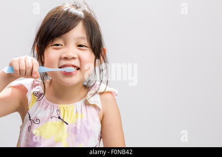 Süße Asiatin, Zähne putzen, weißen Hintergrund Studio isoliert. Stockfoto