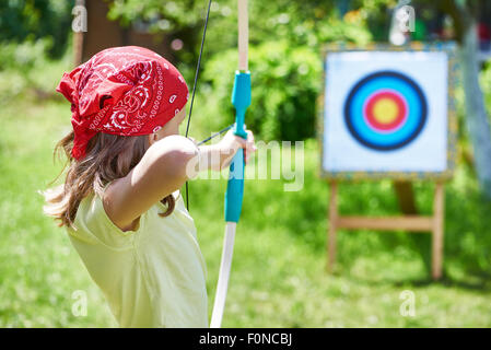 Mädchen mit Bogenschießen Sport Ziel am sonnigen Sommertag Stockfoto