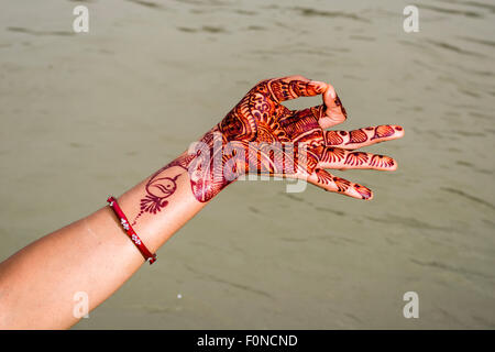 Eine Henna bemalte Hand zeigt die Mudra "Gyan Mudra" an den Ghats von dem heiligen Fluss Ganges, Rishikesh, Uttarakhand, Indien Stockfoto