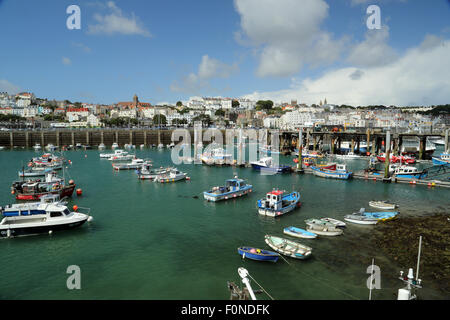 Boote im Hafen von St. Peter Port, Guernsey, Channel Islands, mit Häusern und Restaurants im Hintergrund. Stockfoto