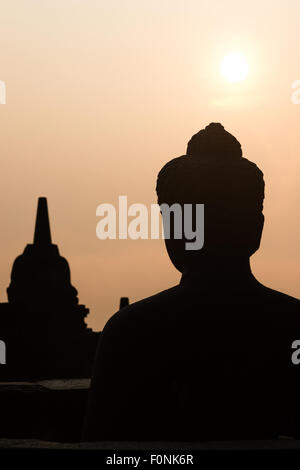 Silhouetten von einer Buddha-Statue auf der Unesco-Weltkulturerbe Website des Borobudur-Tempel in der Morgendämmerung auf der Insel Java, Indonesien, Asien. Stockfoto