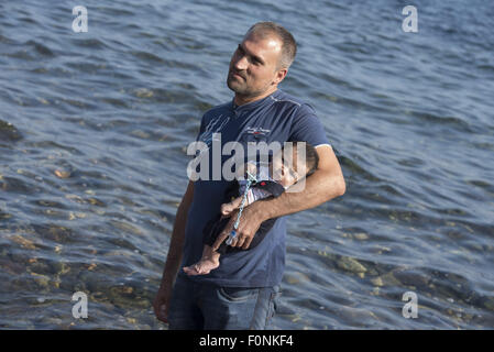 Lesbos, Griechenland. 19. August 2015. Ein syrischer Flüchtling hält ein Neugeborenes nach der Landung an einem Strand auf der Nordseite der Insel Lesbos. Mehr als 120.000 Flüchtlingen und Migranten haben aus der Türkei nach Griechenland bis Ende Juli 2015, nach des UN-Flüchtlingshilfswerks gekreuzt. Bildnachweis: Nikolas Georgiou/ZUMA Draht/Alamy Live-Nachrichten Stockfoto