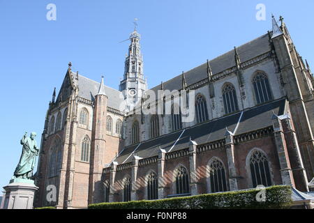 Grote oder St. Bavo Kirche, auf dem Grote Markt Platz in der Stadt von Haarlem, Niederlande. Statue von Laurens Janszoon Coster Stockfoto