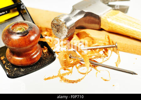 Hammer und Hobel Verlegung auf ein Stück Holz mit Nägeln und Holzspäne Stockfoto