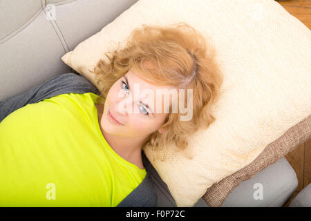 Eine junge, plus Size Frau auf dem Sofa entspannen. Stockfoto