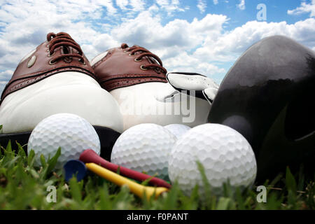 Golf-Schuhe und Ausrüstung, die sitzen auf dem Rasen mit einem strahlend blauen Himmel im Hintergrund Stockfoto