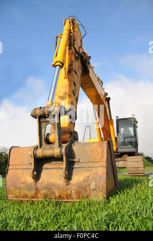 Riesige Bagger auf der grünen Wiese bereit zu arbeiten Stockfoto