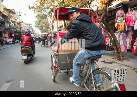 Rikscha-Hanoi, Blicke ein Fahrer eine Fahrradrikscha in Hanoi über seine Schulter und geben eine Tour von Hanoi, Vietnam Stockfoto