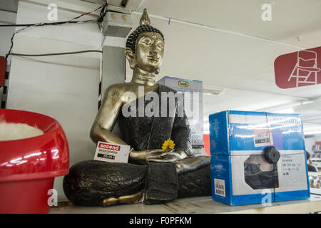 Buddha-Statue unter Second Hand Ware zum Verkauf an diesem 'Seconds' Shop in Terrassa, in der Nähe von Barcelona, Katalonien, Spanien. Stockfoto