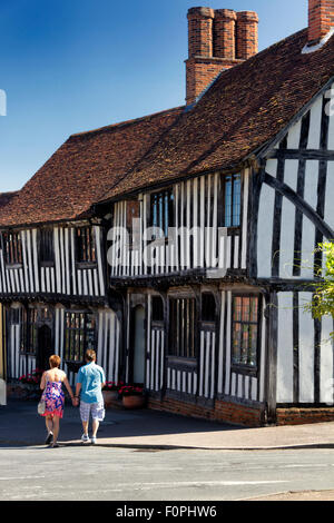 Touristen zu Fuß vorbei an historischen Fachwerkhaus beherbergt, Church Street, Lavenham, Suffolk, UK Stockfoto