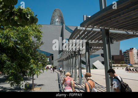 Gehweg und Disseny Designmuseum in Barcelona, Spanien. Mit Agbar-Turm im Hintergrund. Stockfoto