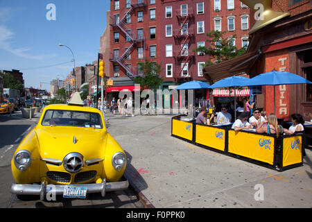 USA, Staat New York, New York City, Manhattan, Greenwich Village, gelbe Studebaker Auto außerhalb der Caliente Cab Co Bar. Stockfoto