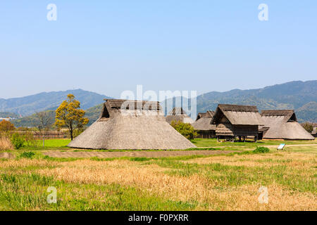 Japan, Yoshinogari Eisenzeit Historical Park. Minami-no-mura, South Village, rekonstruiert Yayoi Zeitraum Eisen - alter pit-Wohnungen. unter strahlend blauem Himmel. Stockfoto