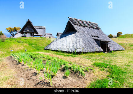 Japan, Yoshinogari Eisenzeit Historical Park. Minami-no-mura, South Village, rekonstruiert Yayoi Zeitraum Eisen - alter pit-Wohnungen. unter strahlend blauem Himmel. Stockfoto