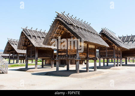 Japan, Yoshinogari Eisenzeit Historical Park. Rekonstruierte Kura-zu-Ichi Marktplatz Bereich mit zwei Reihen von drei erhöhten Yayoi Vorratskammern. Stockfoto