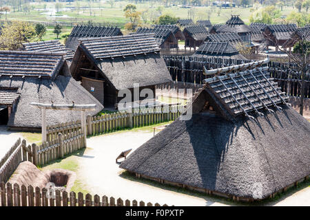 Japan, Yoshinogari Eisenzeit Historical Park. Die rekonstruierten Kura-zu-Ichi, Markt, mit erhöhten Lagerhäusern und eine typische Grube Wohnhaus. Stockfoto