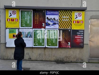 Frau schaut Ausstellungsplakate M50 Arts District Shanghai China Stockfoto