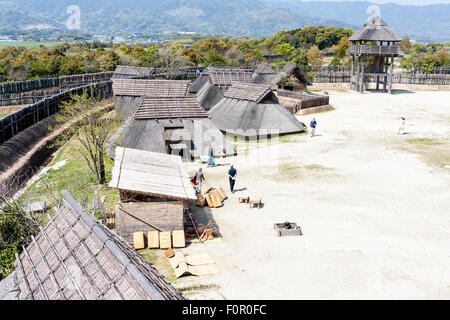 Japan, Yoshinogari Historical Park. Rekonstruierte Yayoi Dorf, Kura-zu-ichi, mit Lagerhäusern auf dem Markt hinter Holz- Verteidigung Wand. Stockfoto