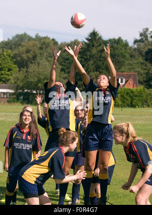 Weibliche Schülerinnen und Schülern spielen Rugby, Surrey, Großbritannien. Stockfoto