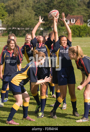 Weibliche Schülerinnen und Schülern spielen Rugby, Surrey, Großbritannien. Stockfoto