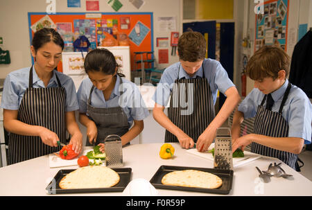 Schüler der weiterführenden Schule bereitet gesunde Zutaten für eine Pizza in einer Kochstunde, Surrey, Großbritannien, zu. Stockfoto