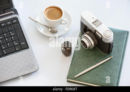 35mm Vintage Photocamera Tagebuch mit Film, Tasse Kaffee Stift und Notizbuch Stockfoto