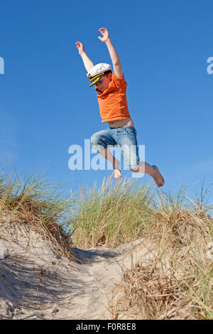 Junge springt in den Dünen, Warnemünde, Rostock, Mecklenburg-West Pomerania, Deutschland Stockfoto