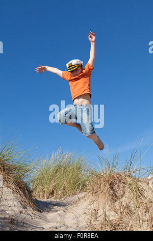 Junge springt in den Dünen, Warnemünde, Rostock, Mecklenburg-West Pomerania, Deutschland Stockfoto