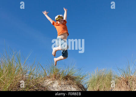 Junge springt in den Dünen, Warnemünde, Rostock, Mecklenburg-West Pomerania, Deutschland Stockfoto