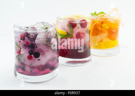 Drei alkoholfreie Frucht-Cocktails mit Eistee und geschnittene Obst auf weißem Hintergrund. Kalter Sommer Getränk Stockfoto