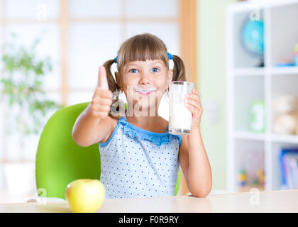 Kind trinkt Milch und Daumen auftauchen Stockfoto