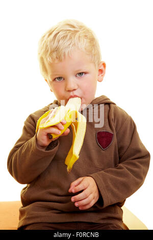 Kleiner Junge isst eine Banane Stockfoto