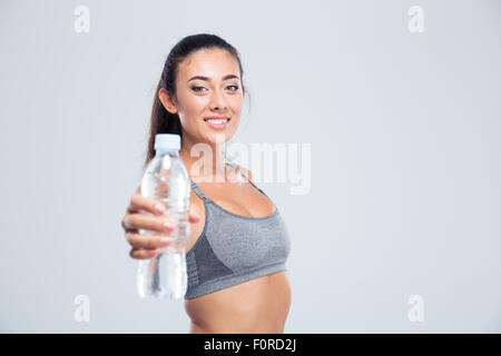 Porträt einer lächelnden Fitness-Frau mit Flasche mit Wasser isoliert auf weißem Hintergrund Stockfoto