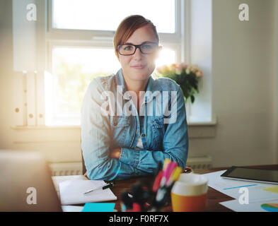 Erfolgreiche Geschäftsfrau, die Arbeiten im Büro, Blick in die Kamera Stockfoto