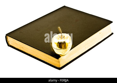 Goldener Apfel auf altes Buch isoliert auf weiss Stockfoto