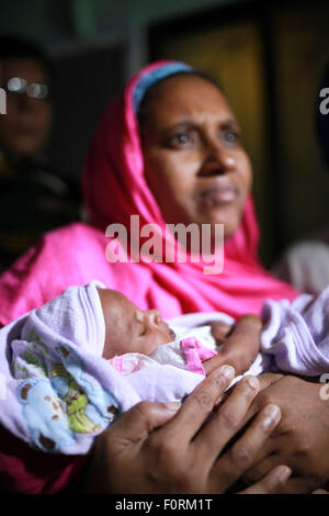 DHAKA, Bangladesch-16. August: Suraiya Säugling war nahm Kugel im Leib der Mutter zu ihrer Mutter am Medical College Hospital in Dhaka, Bangladesch im 16. August 2015 verschoben. Die Mutter Najma Begum wurde während einer Schießerei zwischen zwei Fraktionen der Chhatra League am Donnerstag 23. Juli in Doarpar Karigarpara der Magura Stadt erschossen. Die Kugel ging auch durch das Baby in ihrem Bauch. Eine Kugel hatte über die Rechte Seite des Organismus des Kindes übergeben. Stockfoto